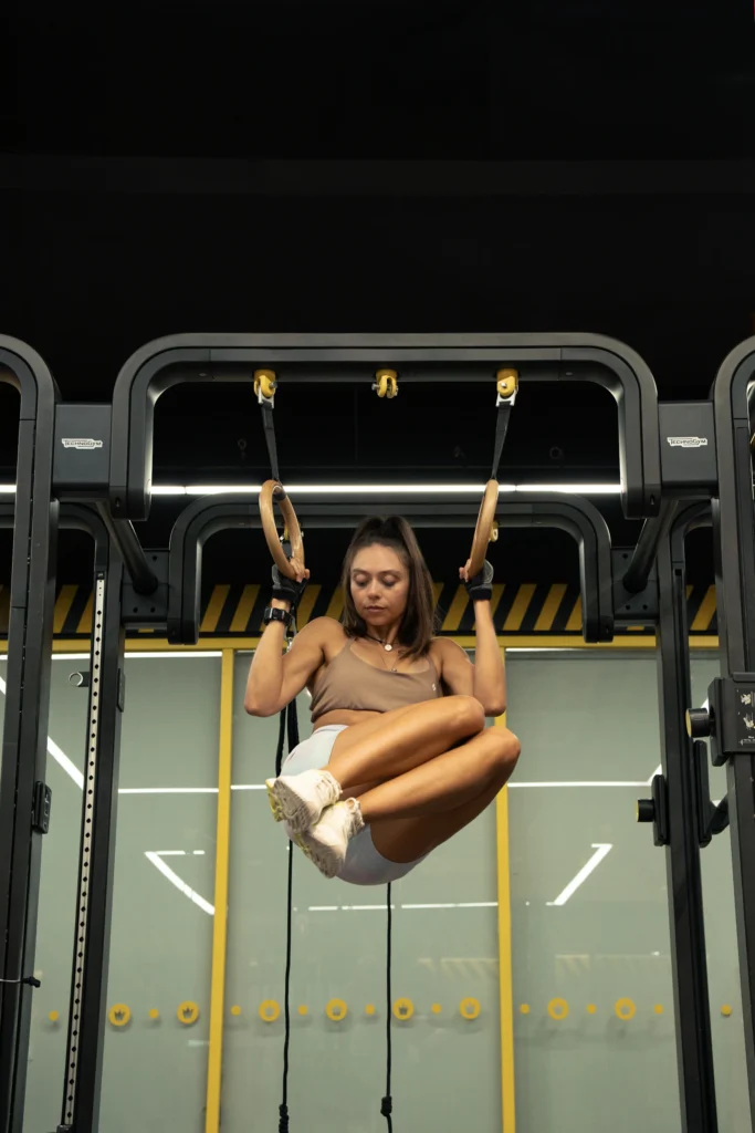 Athlete doing a hanging knee raise in ab straps