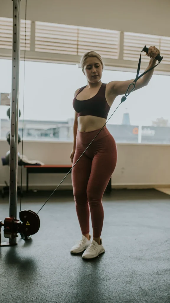 Woman training on a cable machine with an ankle strap