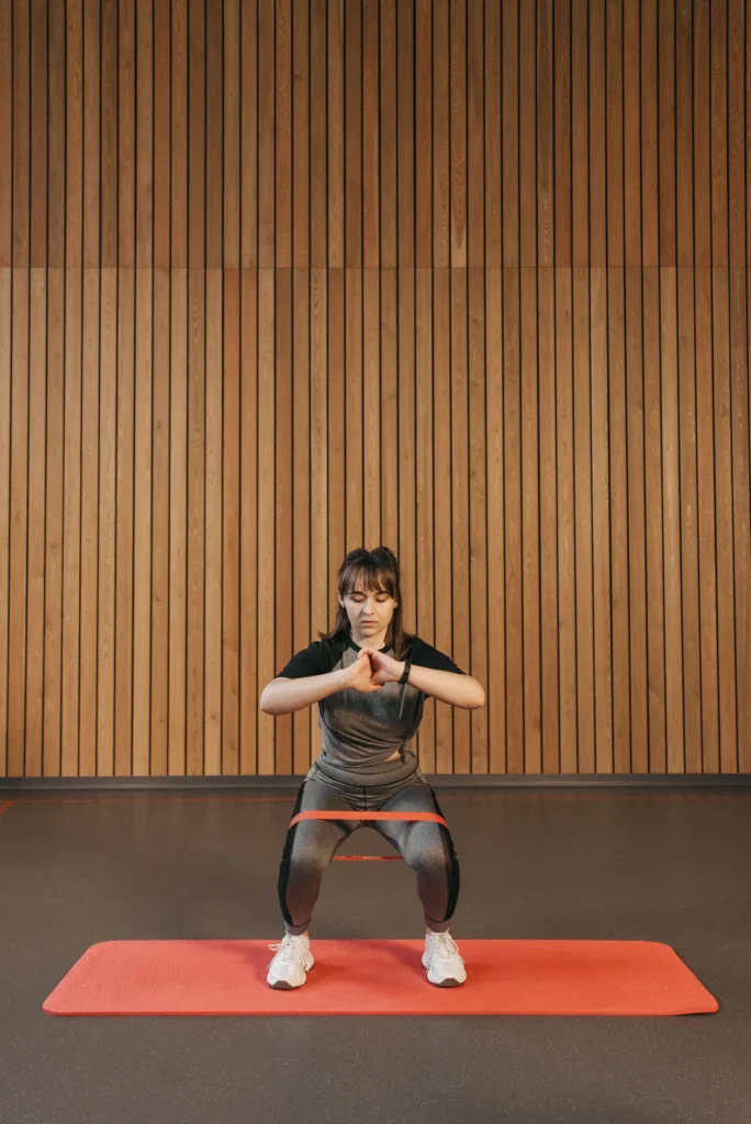 Woman squatting with a fabric resistance band above the knees