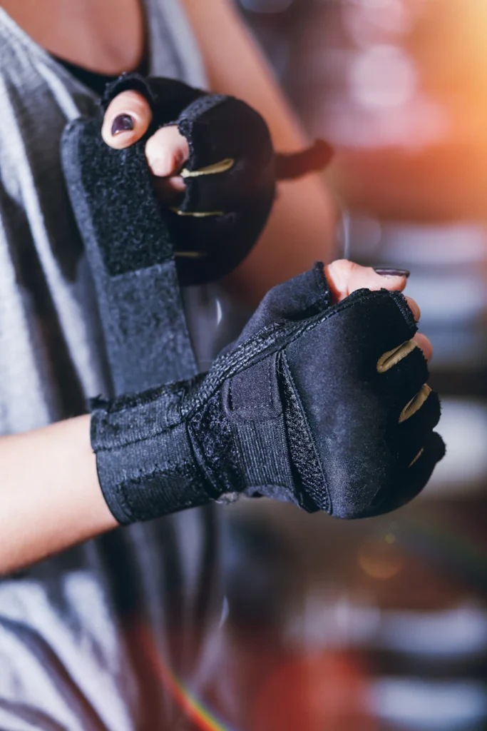 Gym glove with wrist support strap on a lifter’s hand