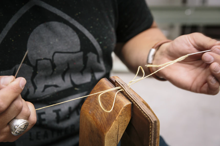 Hand stitching a leather component during accessory construction
