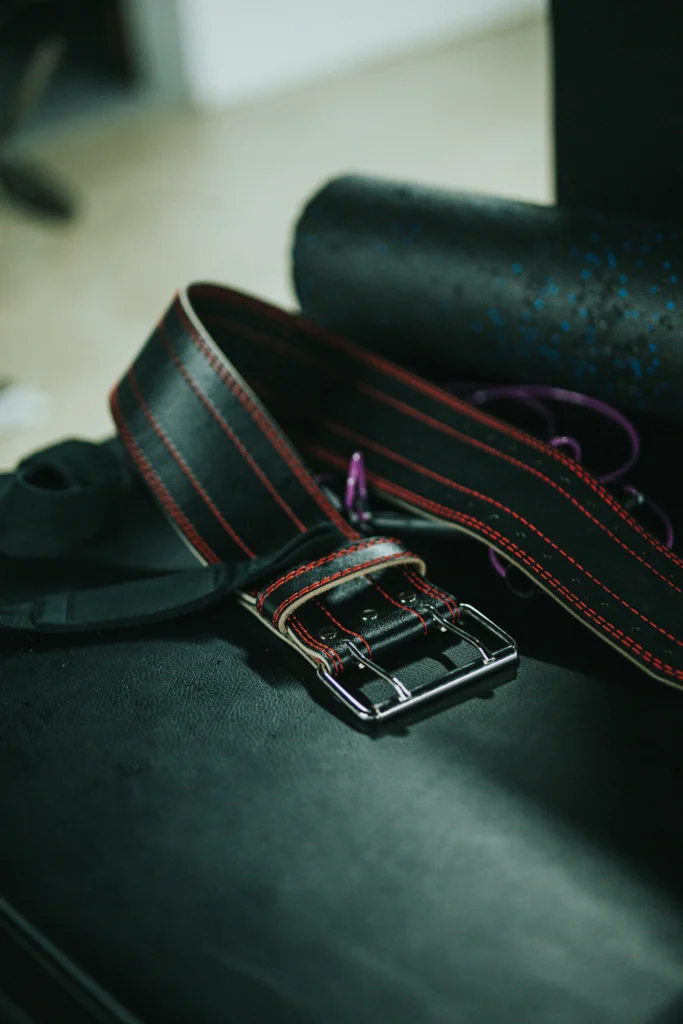 Black leather weightlifting belt with contrast stitching and metal buckle