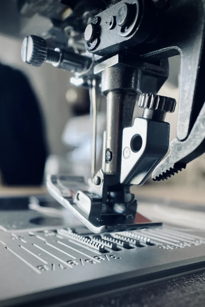 Industrial sewing machine needle stitching a strap
