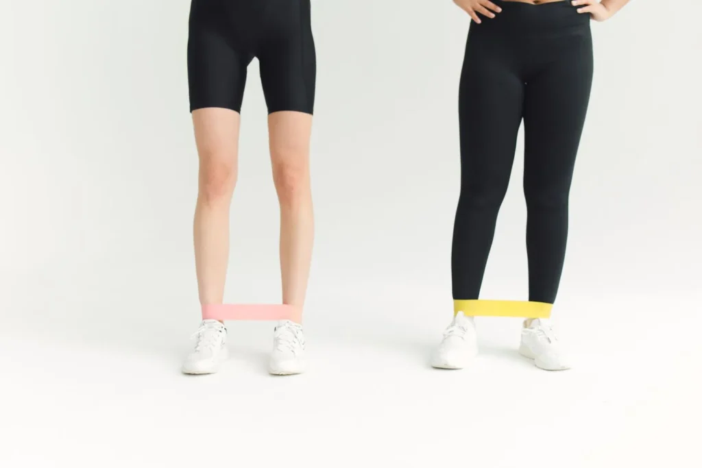 Two people wearing mini loop bands around the ankles