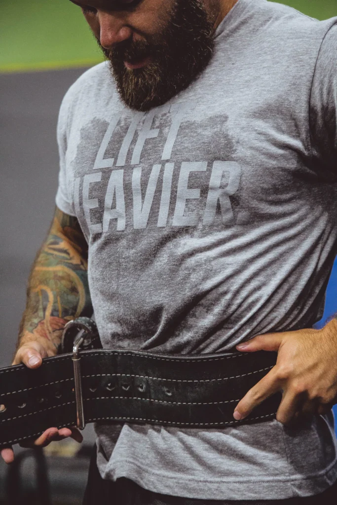 Lifter fastening a thick black leather prong belt before a heavy lift