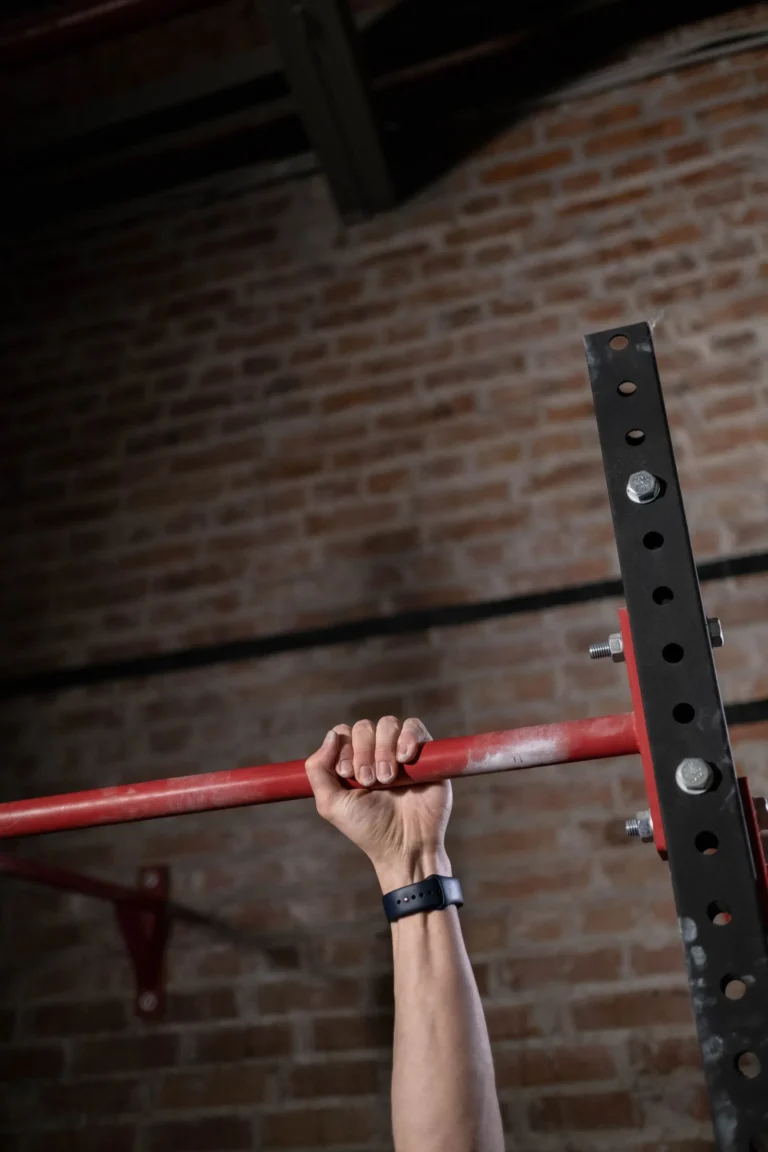 Hand gripping a pull-up bar in a training gym