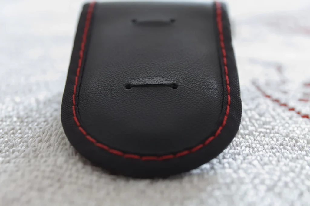 Close-up of even contrast stitching on a black leather accessory