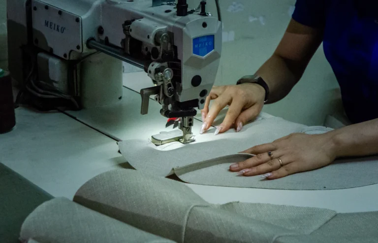 Industrial sewing machine stitching fabric in a workshop