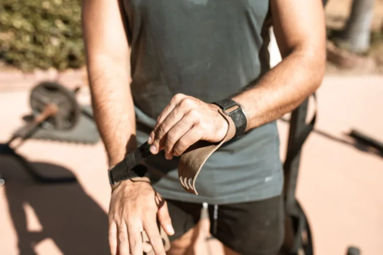 Lifter adjusting a wrist strap before a heavy pull