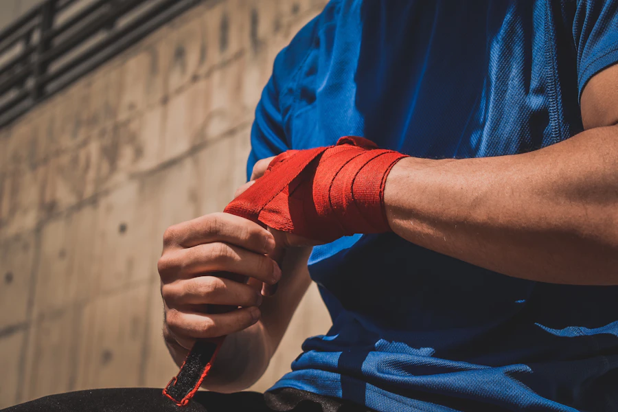 Athlete fastening red wrist wraps before weightlifting